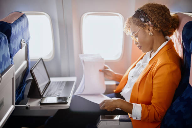 business travel. mature businesswoman sitting in an airplane using a laptop.